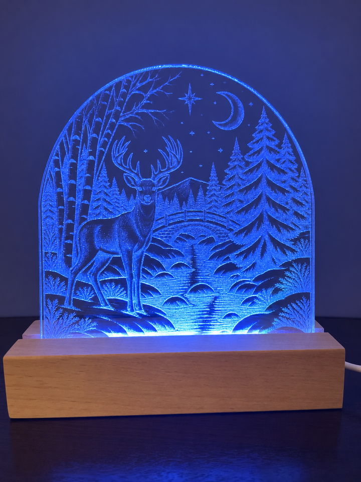 Blue LED engraved acrylic display featuring a deer in a winter forest on a natural wood base.
