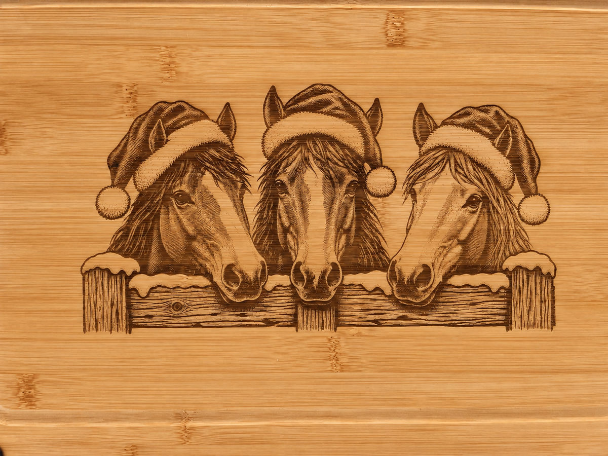 Close-up of Christmas horses engraved on warm honey-toned bamboo with natural grain visible.