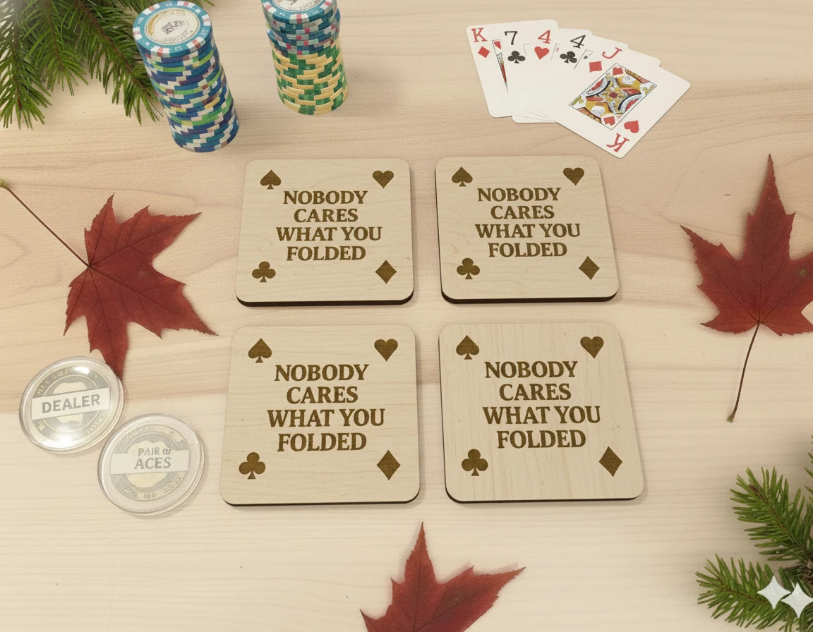 Wooden coasters with 'Nobody cares what you folded' text on a table.