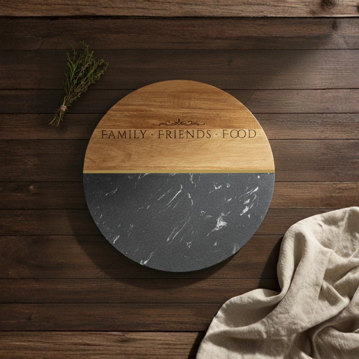 Round wooden and marble cutting board with 'FAMILY FRIENDS FOOD' text on a wooden surface.