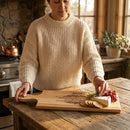 Woman in a kitchen preparing a cheeseboard with a personalized cutting board.