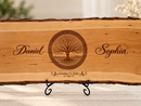 Close-up of a personalized live-edge wedding board with Tree of Life engraving, custom names and wedding date.
