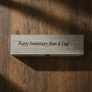 Wooden block with 'Happy Anniversary Mom & Dad' text on a wooden surface